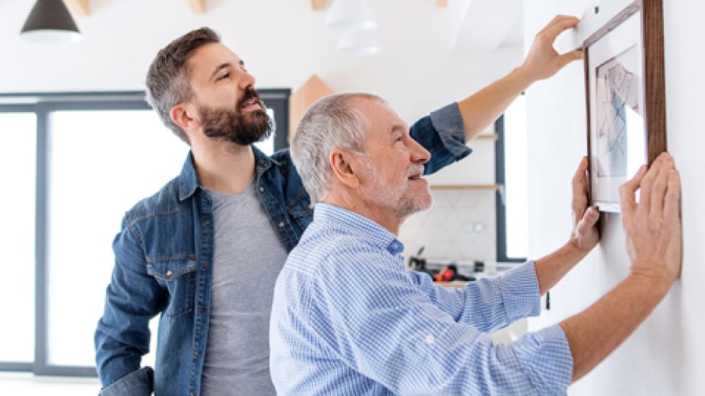 Father and son working together with the goal of hanging a painting