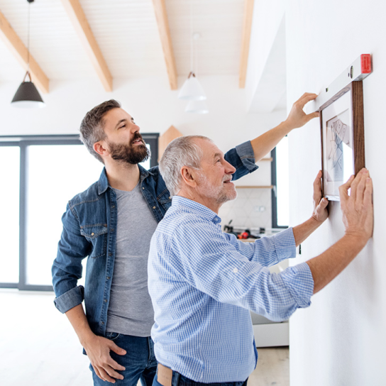 Father and son working together with the goal of hanging a painting